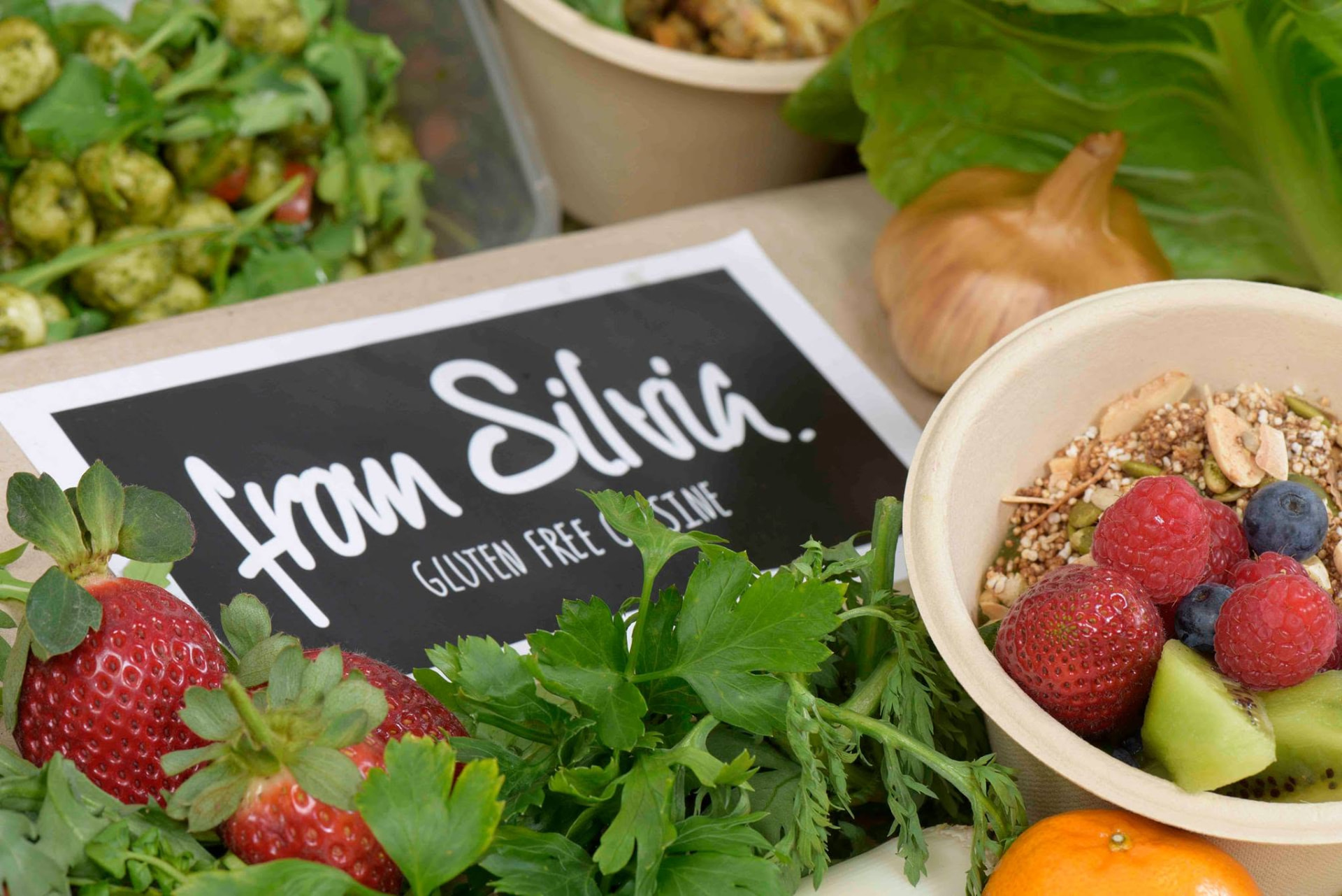 From Silvia gluten free cuisine sign among fresh produce and a breakfast bowl